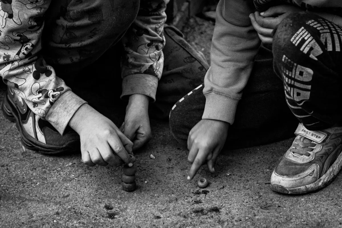 Black and white photo of children playing a traditional game in Istanbul.