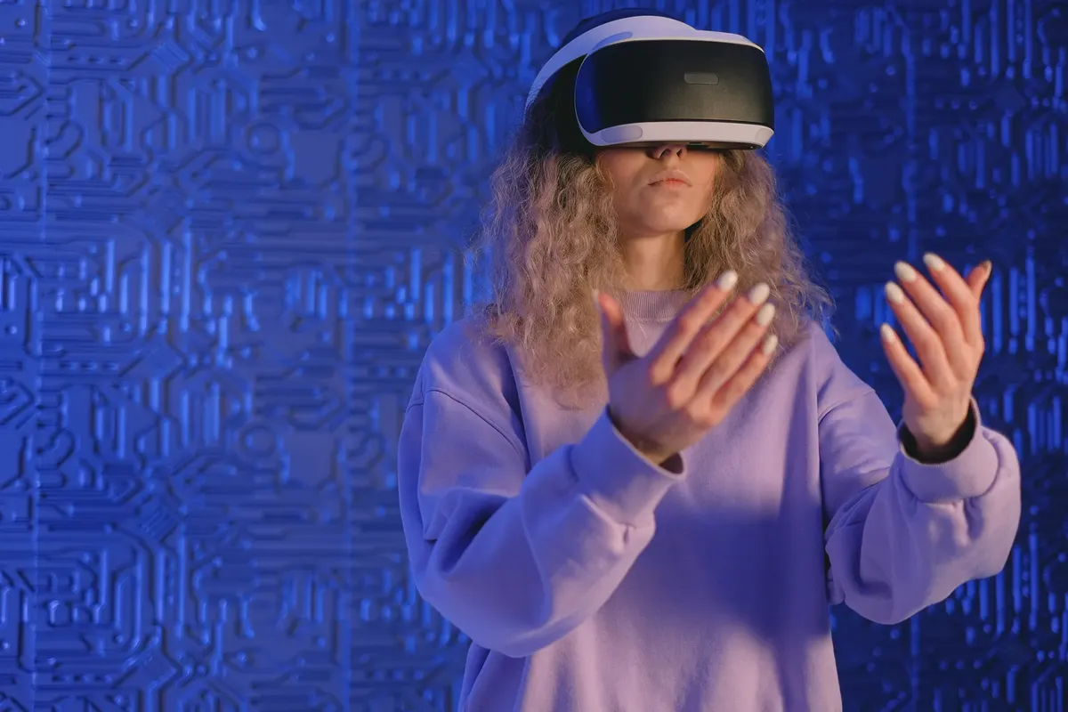 A woman experiencing virtual reality gaming with VR headset in a modern tech setting.
